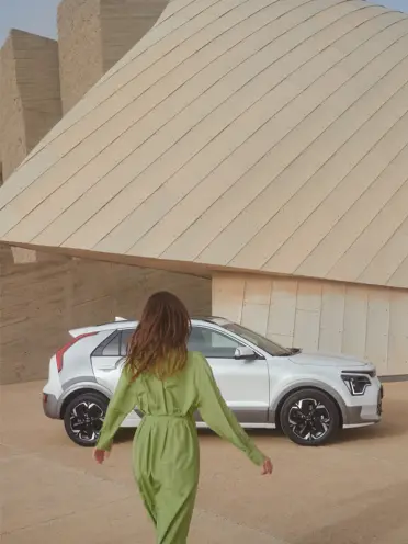 Kia Niro EV Design mit Frau im gr&uuml;nen Kleid