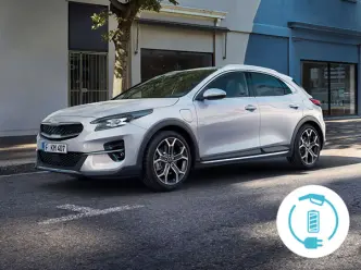 Kia XCeed PHEV mit Ladesymbol vor Geb&auml;ude