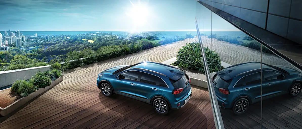 Kia Niro auf Holzterasse &uuml;ber den D&auml;chern einer Stadt