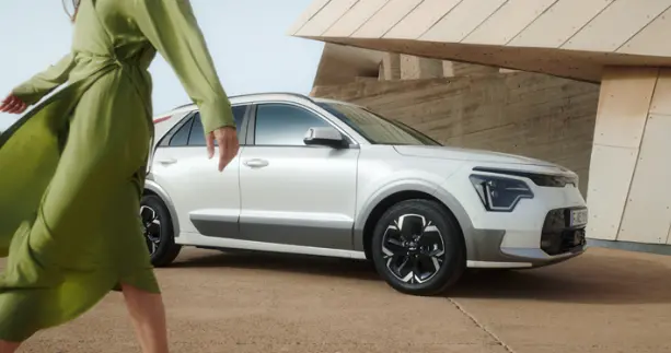 Kia Niro EV Design mit Frau im gr&uuml;nen Kleid