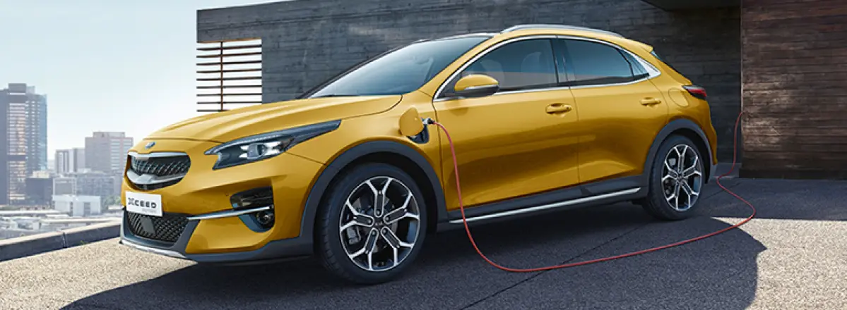 Kia XCeed PHEV an Ladestaion auf Auffahrt seitliche Frontansicht